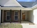 Inviting front porch with wood pillars, brick accents, and charming wood door at 561 Old Loganville Rd, Loganville, GA 30052