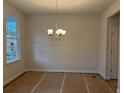 Bright dining room with neutral walls, a modern chandelier, and a large window at 146 Riverbirch Way, Dallas, GA 30157