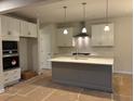 Modern kitchen with stainless steel appliances, white cabinets, marble backsplash, and a center island at 146 Riverbirch Way, Dallas, GA 30157