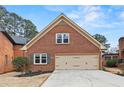 Attached two-car garage featuring brick facade, gabled roof, and driveway at 2976 Wilsons Crossing Ct, Decatur, GA 30033