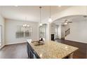 Kitchen with granite island, stainless sink and archway leading to living room at 5015 Rapahoe Trl, Atlanta, GA 30349