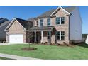 Beautiful two-story brick home with a well-manicured lawn and an attached two-car garage at 718 Ocmulgee Crossing, Locust Grove, GA 30248