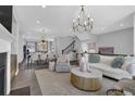 Spacious open-concept living area with fireplace, chandelier, and seamless flow to dining area at 235 Commons Ave, Woodstock, GA 30188