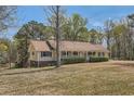 Ranch style home with a long porch and mature trees in the yard at 12142 Panhandle Rd, Hampton, GA 30228