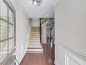 Bright foyer features hardwood floors, staircase, and wainscoting at 2275 W Village Se Ln, Smyrna, GA 30080