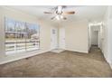 Bright living room with large window, ceiling fan, neutral carpet, and fresh paint at 1899 Lathrop Se St, Atlanta, GA 30315