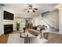 Inviting living room boasts a fireplace, modern ceiling fan, and stylish staircase at 2280 Whitestone Pl, Alpharetta, GA 30005