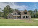 Charming two-story home features a lush green lawn and a welcoming brick and siding facade at 30 Homesite Cooper E Cv, Fayetteville, GA 30215