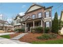 Beautiful two-story home featuring brick and siding exterior, front porch, and landscaped front yard at 4492 Arbor Crest Ct, Suwanee, GA 30024