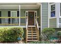 Inviting front porch with a wooden door and a charming wreath, surrounded by lush greenery at 90 Lakeside Dr, Hiram, GA 30141