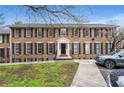 Brick townhouse with black shutters and a manicured lawn, offering a classic and inviting curb appeal at 1101 Collier Nw Rd # U6, Atlanta, GA 30318
