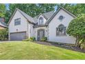 Beautiful home featuring a well-manicured lawn and a symmetrical design with elegant architectural details at 140 Grosvenor Pl, Atlanta, GA 30328