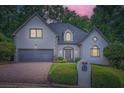 Charming two-story home with a well-manicured lawn, stone accents, and a brick driveway at 140 Grosvenor Pl, Atlanta, GA 30328