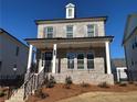 Charming two-story home with a inviting front porch, complemented by a black metal fence and landscaping at 175 Basil Street St, Cumming, GA 30040