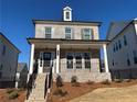 Charming two-story home with a inviting front porch, complemented by a black metal fence and landscaping at 175 Basil Street St, Cumming, GA 30040