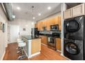 Modern kitchen with stainless appliances, wooden cabinets, kitchen island, and a stackable washer and dryer at 5300 Peachtree Rd # 1311, Atlanta, GA 30341