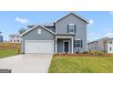Charming two-story home displaying attractive curb appeal with manicured lawn, two-car garage, and complementary siding at 7224 Lacey Dr, Douglasville, GA 30134