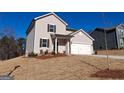 Attractive two-story home showcasing neutral siding, a two-car garage, and landscaping on a sloped lawn under a blue sky at 7224 Lacey Dr, Douglasville, GA 30134