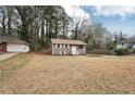 View of home featuring a well-manicured lawn, light colored siding, and a detached garage at 4042 Sweetbriar Ln, Forest Park, GA 30297