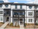 Townhome featuring black and white exterior with a covered porch and balcony at 1053 Knoxboro Ln, Woodstock, GA 30188