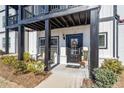 Exterior of a townhome with a welcoming porch, decorative wreath, and manicured landscaping at 1053 Knoxboro Ln, Woodstock, GA 30188
