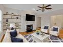 Cozy living room boasts hardwood floors, a ceiling fan, and floating shelves at 107 Vinings Forest Se Cir, Smyrna, GA 30080