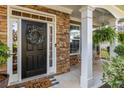 Inviting front porch featuring stone columns, decorative wreath, and a cozy seating area at 4770 Shiloh Springs Rd, Cumming, GA 30040