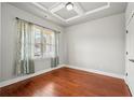Cozy bedroom with tray ceiling, hardwood floors, and bright window at 1602 Renaissance Ne Dr, Conyers, GA 30012