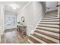 Elegant entryway with wood floors, staircase, console table, and natural light at 119 Ivey Way, Woodstock, GA 30188