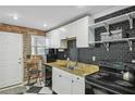 Updated kitchen with granite counters, black appliances, and white cabinets at 24 Daniel St # 6, Atlanta, GA 30312