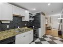 This kitchen has granite countertops, black appliances, and a checkered floor at 24 Daniel St # 6, Atlanta, GA 30312