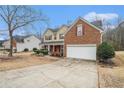 Beautiful home showcasing brick and siding exterior, complemented by red shutters and well-maintained lawn, plus a two car garage at 750 Beckenham Walk Dr, Dacula, GA 30019