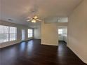 Bright living room featuring dark laminate floors, a ceiling fan and direct access to the kitchen at 275 Circle Rd, Dacula, GA 30019
