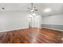 Bright living room with hardwood floors, ceiling fan, and neutral paint color scheme at 5745 River Ridge Ln, Sugar Hill, GA 30518