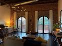 Spacious living room features exposed brick wall, high ceilings, and access to private balcony at 184 Sw Walker Street # E, Atlanta, GA 30313
