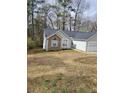 Cozy one-story house with stone details, gray siding, and lush trees in a quiet neighborhood at 2071 Boone Pl, Snellville, GA 30078