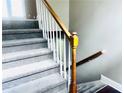 Staircase featuring carpeted steps, white spindles, and a wood handrail at 4415 Yates Rd, Atlanta, GA 30337