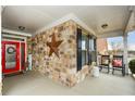 Cozy front porch with stone accent wall, rocking chairs, and a bright red door at 505 Appalachian Woods Dr, Canton, GA 30114