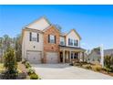 Inviting two-story home with brick and siding, double garage, and professionally landscaped front yard at 1645 Fuma Leaf Way, Mcdonough, GA 30253