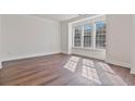 Bright room featuring hardwood floors, three windows bringing in light, and white walls and trim at 3130 Caney Creek Ln, Cumming, GA 30041