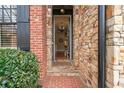 Elegant stone-clad entryway featuring a brick walkway and a glimpse into the home's interior at 13029 Dartmore Ave, Alpharetta, GA 30005