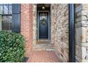 Charming front door with brick accents, stone details, and a welcoming entrance adorned with a wreath at 13029 Dartmore Ave, Alpharetta, GA 30005