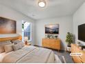 Staged bedroom showcasing natural light, neutral walls, and light wood furniture at 2399 Coach Way, Jonesboro, GA 30236