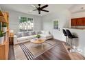 Bright, staged living room features a white sectional couch, wood floors, and a view to the outside at 2399 Coach Way, Jonesboro, GA 30236