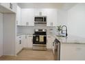 Well-lit kitchen with white cabinets, stainless steel appliances, granite countertops, and modern fixtures at 2414 Rose Palm Pl, Atlanta, GA 30315