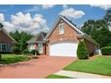 Lovely brick home showcasing a driveway, two-car garage, and beautifully maintained green lawn at 2392 Ivy Mountain Dr, Snellville, GA 30078