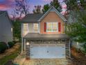 Charming home featuring a stone-accented two-car garage, symmetrical windows and red shutters at 2521 Capella Sw Cir, Atlanta, GA 30331