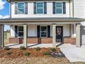 Inviting front porch of a two-story home with brick accents and manicured landscaping at 1633 Fuma Leaf Way, Mcdonough, GA 30253