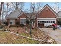 All-brick single-story home with a two-car garage and landscaping in need of some care at 1220 Tab Roberts Rd, Lawrenceville, GA 30043