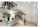 Inviting hallway with carpeted stairs, a glass-topped console table, and potted plants, enhancing the home's ambiance at 145 15Th Ne St # 843, Atlanta, GA 30309